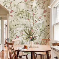 Soft green palm and pink blossom botanical wall mural in a bright dining room