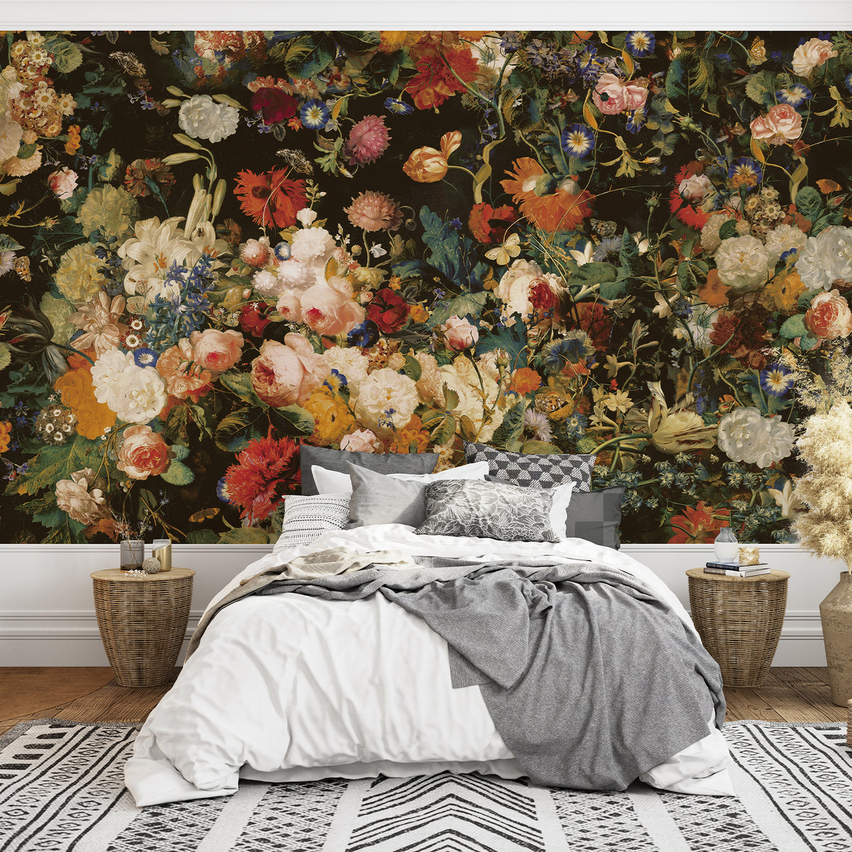 Colorful flower wallpaper mural on a dark background behind a bed with white bedding and a gray throw