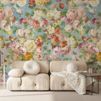 Pastel floral wallpaper mural with pink and yellow blooms behind a cream sofa