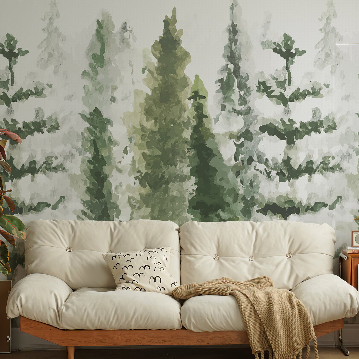 Watercolor pine tree wallpaper mural behind a cream sofa with a wooden frame