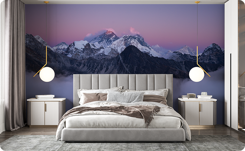 Snow-capped mountain wallpaper mural with a pink and lavender sky behind a gray upholstered bed